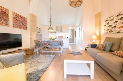 a living room with a couch and a table at Cream Loft Siente Jerez Parking Incluido in Jerez de la Frontera