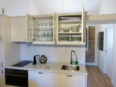 a kitchen with white cabinets and a sink at Cream Loft Siente Jerez Parking Incluido in Jerez de la Frontera