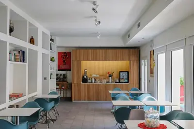 a cafeteria with tables and chairs and a kitchen at La Alcoba del Agua Hotel Boutique in Sanlúcar de Barrameda