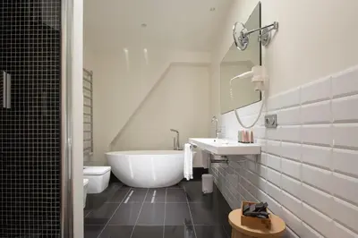 a bathroom with a tub and a sink and a toilet at La Alcoba del Agua Hotel Boutique in Sanlúcar de Barrameda