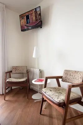 a living room with two chairs and a table at La Alcoba del Agua Hotel Boutique in Sanlúcar de Barrameda