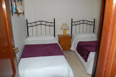 a bedroom with two beds and a lamp on a night stand at Casa Rosalia in Sanlúcar de Barrameda