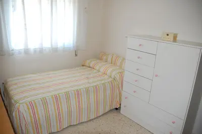 a small bedroom with a bed and a dresser at Casa Rosalia in Sanlúcar de Barrameda