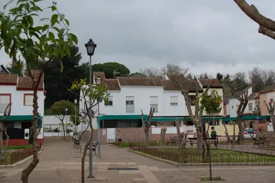 a street in a town with houses and trees at Casa Rosalia in Sanlúcar de Barrameda