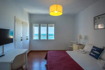 a bedroom with a bed and a desk and a window at OCEANO Family Home free parking by Cadiz4Rentals in Cádiz