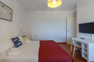 a bedroom with a bed and a desk and a television at OCEANO Family Home free parking by Cadiz4Rentals in Cádiz