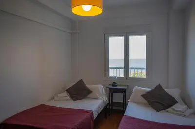 two beds in a room with a window at OCEANO Family Home free parking by Cadiz4Rentals in Cádiz