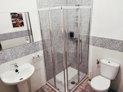 a bathroom with a shower and a toilet and a sink at Hostal Casa Nautilus in Cádiz