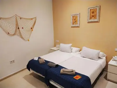a bedroom with two beds with towels on them at Hostal Casa Nautilus in Cádiz