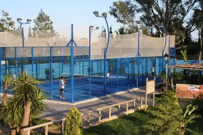 two people playing tennis on a tennis court at Glamping -Bungalows El Faro in Conil de la Frontera
