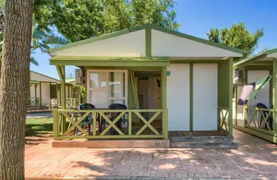 a small house with a porch with a fence at Glamping -Bungalows El Faro in Conil de la Frontera