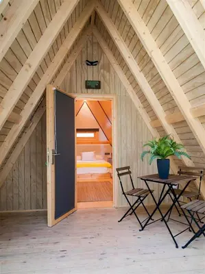 a room with a door and a table and a bedroom at Glamping -Bungalows El Faro in Conil de la Frontera