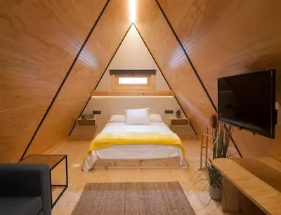 a bedroom with a bed and a tv in a room at Glamping -Bungalows El Faro in Conil de la Frontera