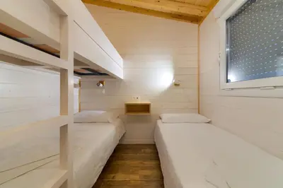 two beds in a small room with a window at Glamping -Bungalows El Faro in Conil de la Frontera