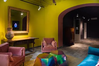 a living room with colorful furniture and a mirror at La Casa del Consul in Cádiz