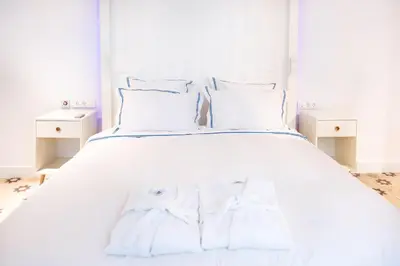 a white bed with two white towels on it at La Casa del Consul in Cádiz