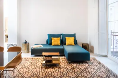 a living room with a blue couch and yellow pillows at La Casa del Consul in Cádiz