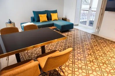 a living room with a table and chairs and a couch at La Casa del Consul in Cádiz