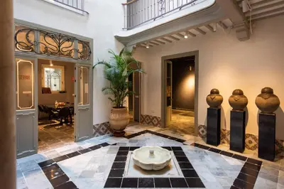 a lobby with a table in the middle of a building at La Casa del Consul in Cádiz
