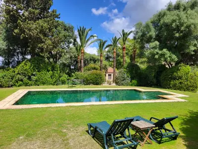 a swimming pool in a yard with two chairs at Casa Viña de Alcántara in Jerez de la Frontera