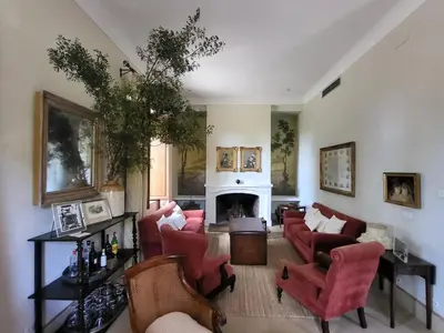 a living room with red chairs and a fireplace at Casa Viña de Alcántara in Jerez de la Frontera