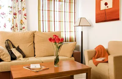 a living room with a couch and a vase of flowers on a table at Casa Palacio Luna in El Puerto de Santa María