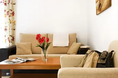 a living room with a couch and a vase of flowers on a table at Casa Palacio Luna in El Puerto de Santa María
