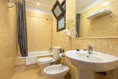 a bathroom with a sink and a toilet and a mirror at Casa Palacio Luna in El Puerto de Santa María