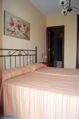 a bedroom with a large bed with a striped bedspread at Casa Palacio Luna in El Puerto de Santa María