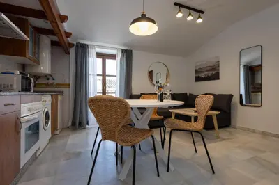 a kitchen and living room with a table and chairs at Casa Palacio Luna in El Puerto de Santa María