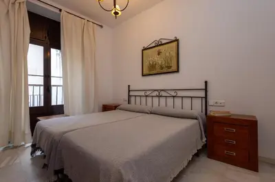 a bedroom with a bed and a picture on the wall at Casa Palacio Luna in El Puerto de Santa María