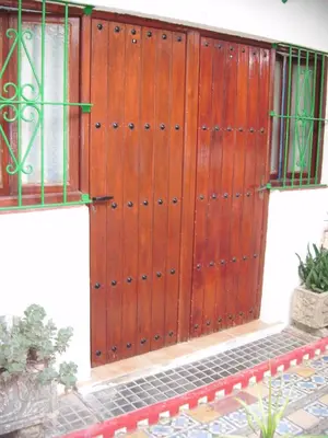 a wooden door with a gate on the side of a building at Pensión San Andrés I in Jerez de la Frontera