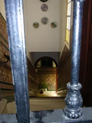 a spiral staircase with plates on the wall and a column at Pensión San Andrés I in Jerez de la Frontera