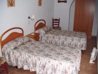 a hotel room with two beds and a table at Pensión San Andrés I in Jerez de la Frontera