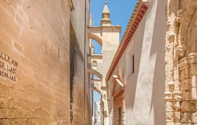 an alley in the city with a tower in the distance at Awesome Home In Arcos De La Frontera in Arcos de la Frontera