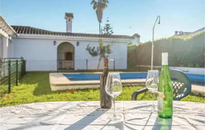 a table with two wine bottles and glasses on it at Awesome Home In Arcos De La Frontera in Arcos de la Frontera