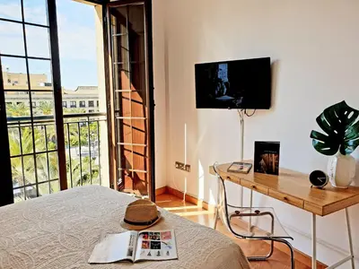 a bedroom with a bed and a table and a television at Sherryflat Fate in Jerez de la Frontera