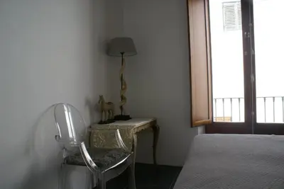 a bedroom with a table and a chair and a lamp at Bed & Breakfast Casa El Sueño in Arcos de la Frontera
