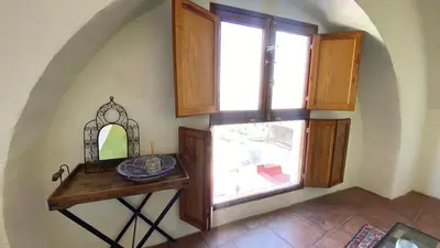 a room with a table with a mirror and a window at Bed & Breakfast Casa El Sueño in Arcos de la Frontera