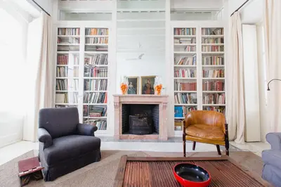 a living room with a fireplace and a chair at Apartamentos La Botanica, Cadiz in Cádiz