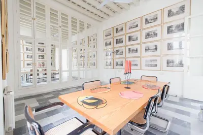 a dining room with a wooden table and chairs at Apartamentos La Botanica, Cadiz in Cádiz