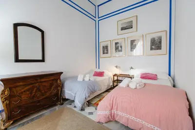 a bedroom with two beds and a mirror at Apartamentos La Botanica, Cadiz in Cádiz