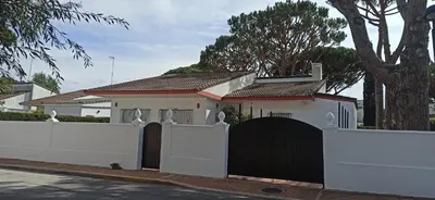 a white house with a gate and a fence at Chalet en Roche in Conil de la Frontera