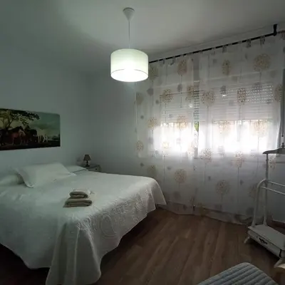 a bedroom with a white bed and a window at Chalet en Roche in Conil de la Frontera