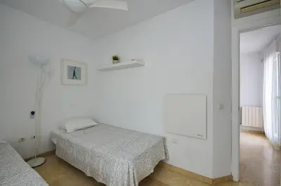 a white room with two beds and a lamp at Adosado Dulce Barrosa in Chiclana de la Frontera