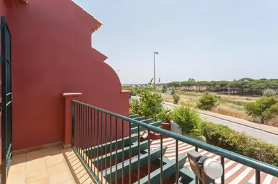 a balcony with green stairs and a road at Adosado Dulce Barrosa in Chiclana de la Frontera