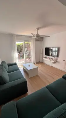 a living room with two couches and a tv at Adosado Dulce Barrosa in Chiclana de la Frontera