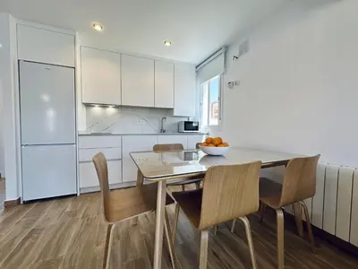 a kitchen and dining room with a table and chairs at Apartamentos Turísticos Santo Rostro in Chipiona