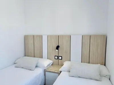 two beds sitting next to each other in a bedroom at Apartamentos Turísticos Santo Rostro in Chipiona