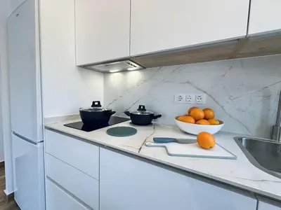 a kitchen with a counter with a bowl of oranges at Apartamentos Turísticos Santo Rostro in Chipiona
